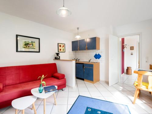 a living room with a red couch and a kitchen at Apartment Kiefernweg by Interhome in Ramersbach