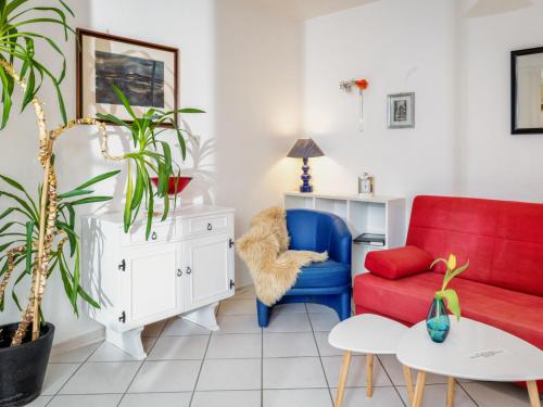 ein Wohnzimmer mit einem roten Sofa und einem blauen Stuhl in der Unterkunft Apartment Kiefernweg by Interhome in Ramersbach