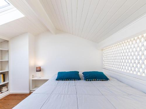 Cette chambre blanche dispose d'un lit avec des oreillers bleus. dans l'établissement Studio Le Platin by Interhome, à La Palud
