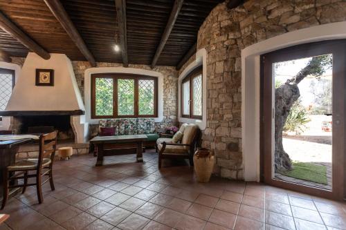 een woonkamer met een stenen muur en een open haard bij Villa Antonietta in Alliste