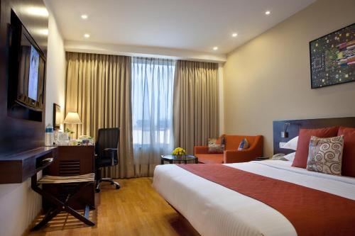 Habitación de hotel con cama grande y escritorio. en Lemon Tree Premier, Ulsoor Lake, Bengaluru, en Bangalore