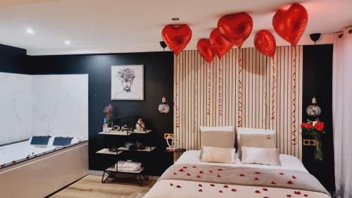 un dormitorio con corazones rojos colgando sobre una cama en Cosy & Jacuzzi 15 mn de Lyon, en Givors