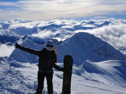 a person holding a snowboard on top of a mountain at Apartment Parkareal - Utoring-12 by Interhome in Bolgen