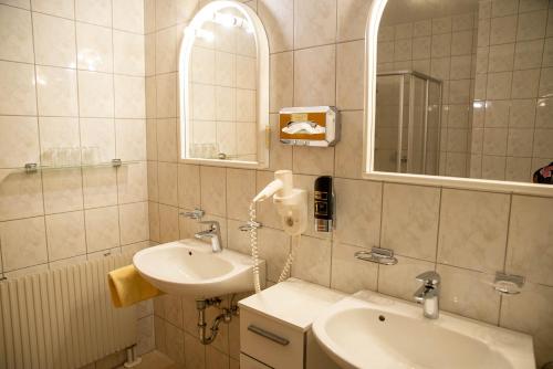 a bathroom with a sink and a mirror at Pension Christine in Großweikersdorf