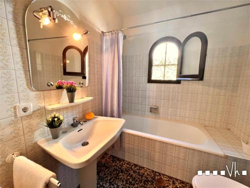 ein Badezimmer mit einem Waschbecken, einer Badewanne und einem Spiegel in der Unterkunft VH CostaBlanca - POLEN in Benissa