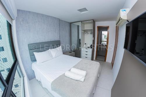 a bedroom with a white bed with towels on it at Apartamento Royale na praia de Boa Viagem in Recife