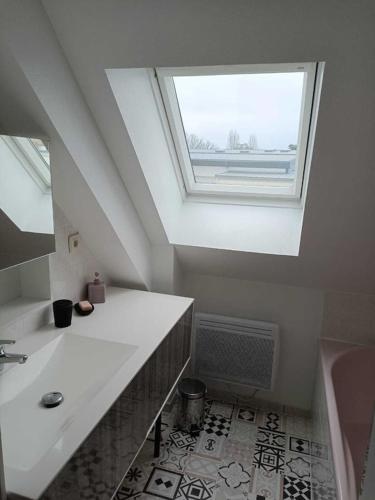 La salle de bains est pourvue d'un lavabo et d'une lucarne. dans l'établissement La maison des vacances, à Trégunc