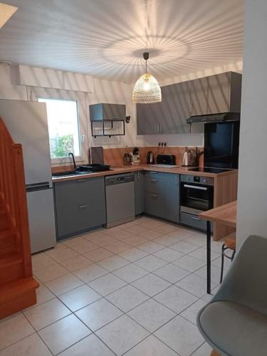 d'une cuisine équipée d'appareils en acier inoxydable et d'un plafond. dans l'établissement La maison des vacances, à Trégunc