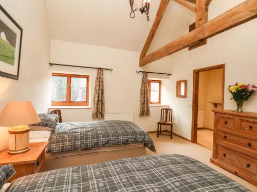 a bedroom with two beds and a desk at The Old Coach House in Pickering