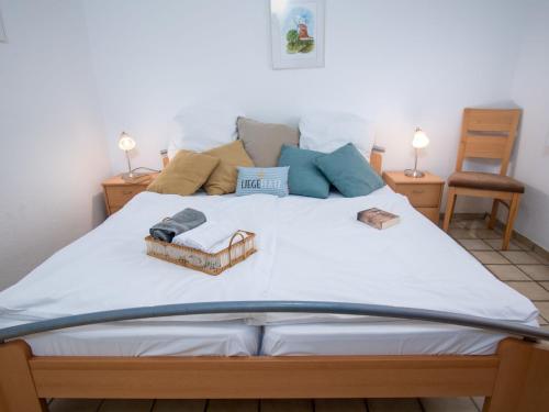 ノルトダイヒにあるApartment Koralle by Interhomeのベッドルーム(白い大型ベッド、ランプ2つ付)