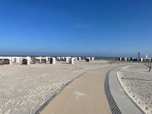 a path on the beach with the ocean in the background at Holiday Home Storchennest by Interhome in Norddeich