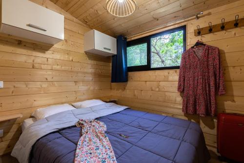 a bedroom with a blue bed in a wooden cabin at Cabane ''Robinson'' dans les arbres de Nature et Océan à côté de la plage in Messanges