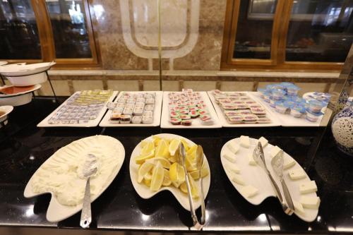 a counter top with plates and bowls andoons on at Royal Eagle Hotel in An Najaf