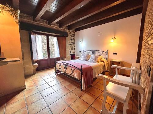 a bedroom with a bed and a chair in a room at Agroturismo el Encuentro in Leza