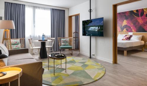 a hotel room with a bed and a living room at Novotel Barcelona Cornellà in Cornellà de Llobregat