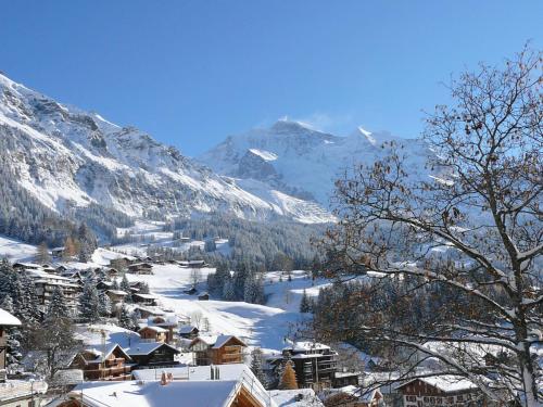 a village in the snow with mountains in the background at Apartment Schweizerhof Apt- B by Interhome in Wengen