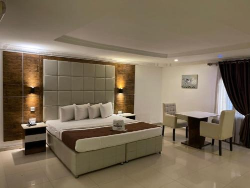 een slaapkamer met een bed, een tafel en een bureau bij Presken Shonibare Estate in Lagos