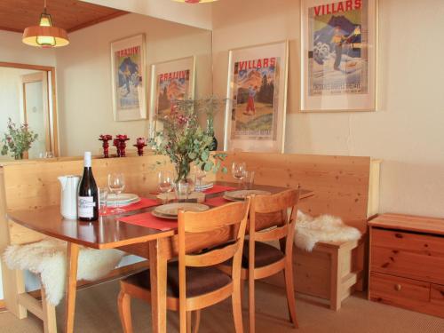 - une table à manger, des chaises et une bouteille de vin dans l'établissement Apartment La Bercière 21 by Interhome, à Villars-sur-Ollon