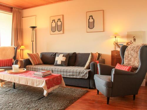 - un salon avec un canapé et deux chaises dans l'établissement Apartment La Bercière 21 by Interhome, à Villars-sur-Ollon