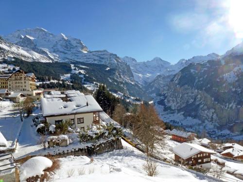 a village covered in snow with mountains in the background at Apartment Breithorn Residence Apt-09 by Interhome in Wengen