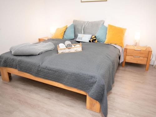 ノルトダイヒにあるHoliday Home Butzel by Interhomeのベッドルーム1室(大型ベッド1台、青と黄色の枕付)