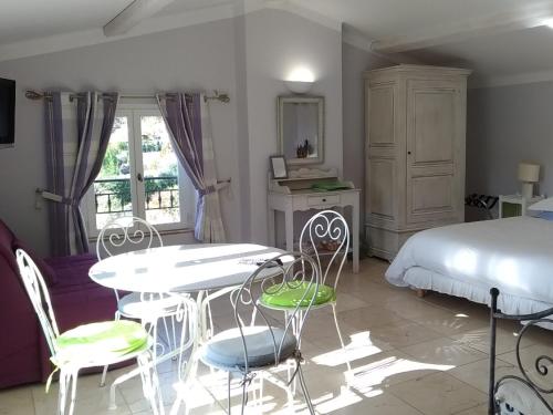 - une chambre avec un lit, une table et des chaises dans l'établissement L'Escale Provençale, à Tourrettes
