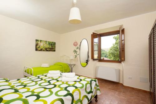een slaapkamer met een groen bed en een raam bij Casale on the lake with sauna and saltwater swimming pool in Baschi