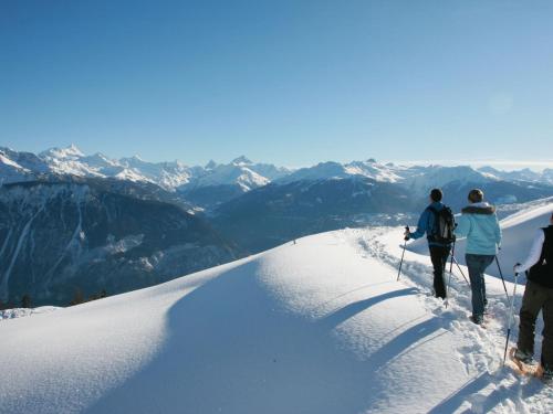a group of three people walking up a snow covered mountain at Apartment Cascades d'Eden 2 by Interhome in Crans-Montana