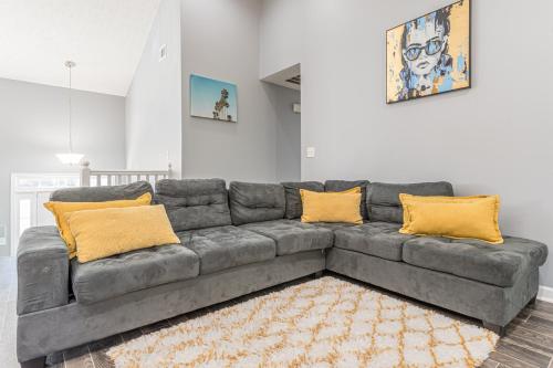 a living room with a gray couch with yellow pillows at Unwind in a Modern Riverdale Home in Riverdale