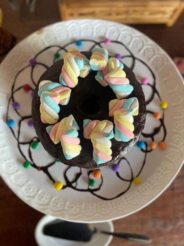 a chocolate doughnut with colorful sprinkles on a plate at Hotel Bertell Inn in Penedo