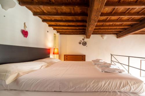 a bedroom with a large white bed with wooden ceilings at Palazzo Vecchio Apartments by Mmega in Florence