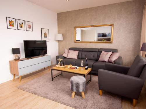 een woonkamer met een bank en een tafel bij Apartment Gezeiten by Interhome in Norddeich