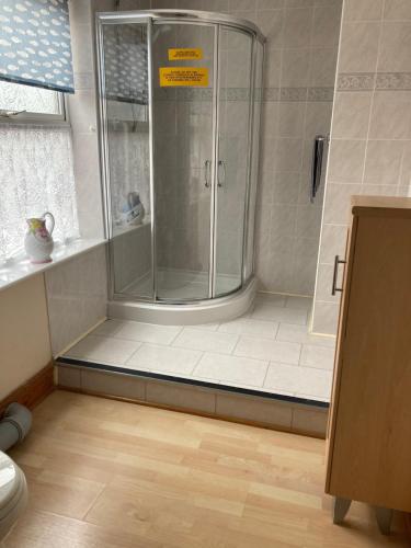 a bathroom with a shower with a glass door at Happy Holiday apartments in Mablethorpe