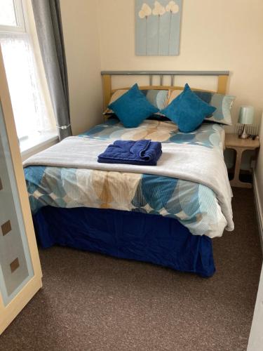 a bedroom with a bed with blue pillows at Happy Holiday apartments in Mablethorpe