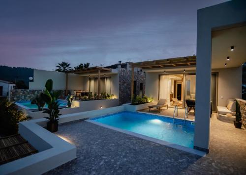 a villa with a swimming pool at night at Kaktus Suites Private Pool in Paliouri