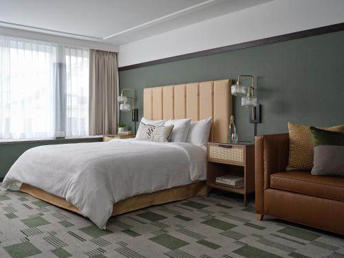 a bedroom with a large bed and a chair at Six South St. Hotel in Hanover