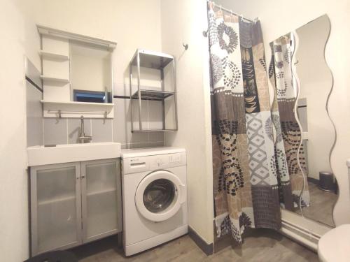 une salle de bain avec une machine à laver et un lavabo dans l'établissement Apartment Le Continental by Interhome, à Saint-Malo