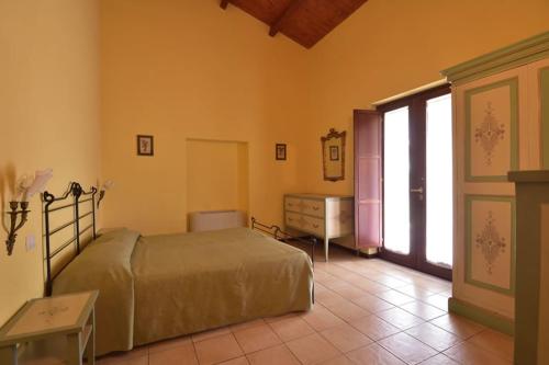 a bedroom with a bed and a dresser and a window at L'Orto di Lucania in Montescaglioso