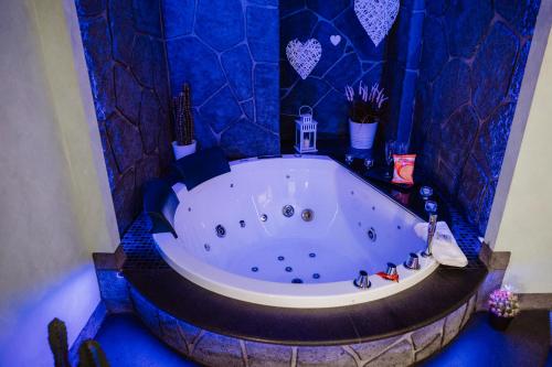 a bathroom with a large tub with blue tiles at TH LUXURY SUITE in Giardini Naxos