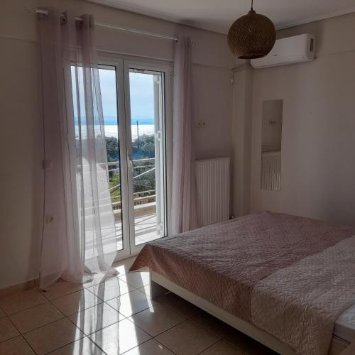 a bedroom with a bed and a large window at Villa Ioulia Malakonda, Eretria ,Greece in Eretria