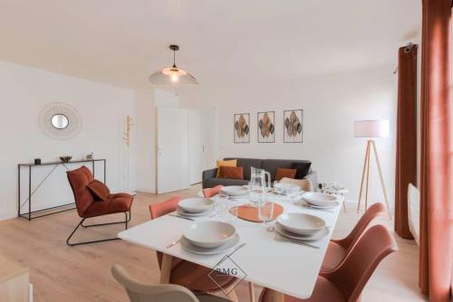 un salon avec une table et des chaises blanches dans l'établissement Royal appartement Disneyland BMYGUEST, à Serris