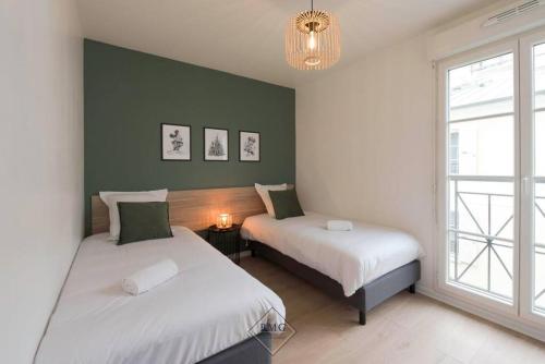 deux lits dans une chambre avec une fenêtre dans l'établissement Royal appartement Disneyland BMYGUEST, à Serris