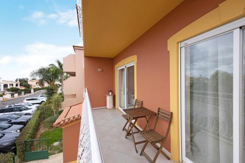 a balcony with two chairs and a table on a building at Palmeiras Reais 110 in Portimão