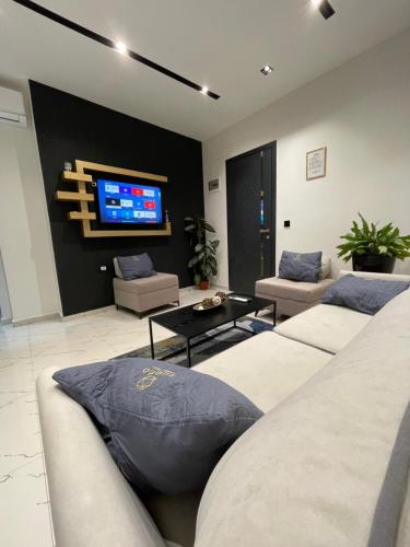 a living room with couches and a flat screen tv at Sueño Apartments & Suites in Tirana