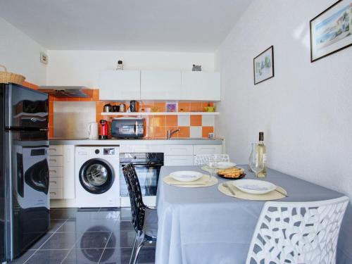 une cuisine avec une table avec deux assiettes dessus dans l'établissement Apartment Les Mas de La Mer-15 by Interhome, à Saint Cyprien Plage