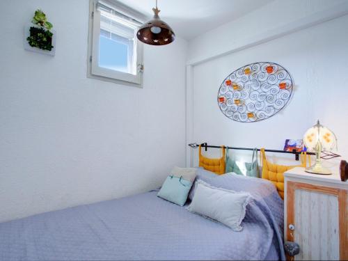 une chambre avec un lit avec des draps bleus et une fenêtre dans l'établissement Apartment Les Mas de La Mer-15 by Interhome, à Saint Cyprien Plage
