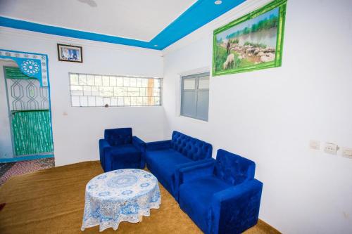 sala de estar con 2 sillas azules y mesa en auberge agla 1, en Ouazzane