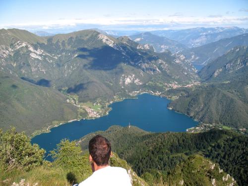 a man standing on top of a mountain overlooking a lake at Apartment Dromaè-3 by Interhome in Mezzolago