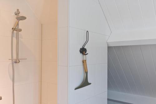 a tool hanging on the wall of a shower at Vakantieverblijf de Trommel in Domburg
