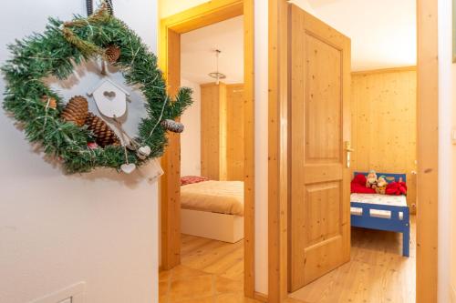 Świąteczny wieniec na ścianie w pokoju w obiekcie Dimora Vallonga w mieście Vigo di Fassa